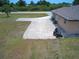 View of the home's front yard with a long driveway and riding lawn mower at 10112 Willmington Blvd, Englewood, FL 34224