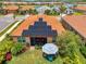 Aerial view showcases home with solar panels, landscaped backyard oasis, and inviting outdoor seating area at 11819 Sistine Ln, Venice, FL 34293