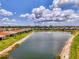 Scenic aerial view of community homes surrounding a serene lake with a fountain, framed by lush green landscaping at 11819 Sistine Ln, Venice, FL 34293