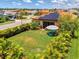 Aerial view of a home with a well-manicured lawn, landscaping, solar panels and backyard seating area at 11819 Sistine Ln, Venice, FL 34293