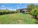 Large, well-maintained backyard featuring lush green grass, tropical plants, and outdoor seating area for relaxation at 11819 Sistine Ln, Venice, FL 34293