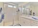 Bathroom featuring glass enclosed shower, white cabinets, solid surface counter, and neutral tile at 11819 Sistine Ln, Venice, FL 34293