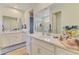 Well-lit bathroom with dual sinks, white cabinetry, and quartz countertop at 11819 Sistine Ln, Venice, FL 34293