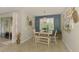 Charming dining area featuring a farmhouse-style table, a decorative window, and sliding glass doors to outdoor space at 11819 Sistine Ln, Venice, FL 34293