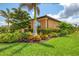 Landscaped home exterior with well-maintained garden, lush lawn, and mature palm tree at 11819 Sistine Ln, Venice, FL 34293
