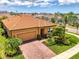 Charming home featuring a manicured lawn, mature landscaping, and a brick-paved driveway at 11819 Sistine Ln, Venice, FL 34293