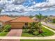 Beautiful single-story home with a clay tile roof, brick driveway, and lush landscaping at 11819 Sistine Ln, Venice, FL 34293