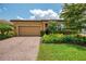 Inviting home exterior with paver driveway, lush landscaping, and well-manicured lawn at 11819 Sistine Ln, Venice, FL 34293