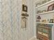 Stylish hallway featuring patterned wallpaper, shelving, and a decorative chest at 11819 Sistine Ln, Venice, FL 34293