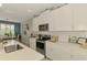 Modern kitchen with white cabinets, stainless steel appliances, quartz countertops, and an adjacent dining area at 11819 Sistine Ln, Venice, FL 34293