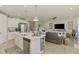 Open-concept kitchen and living area featuring an island with seating and modern appliances at 11819 Sistine Ln, Venice, FL 34293