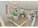 Open concept kitchen and dining area featuring a farmhouse table, white cabinets, and quartz countertops at 11819 Sistine Ln, Venice, FL 34293