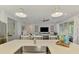 Modern kitchen island featuring quartz countertops and stylish pendant lighting that seamlessly connects with the inviting living room at 11819 Sistine Ln, Venice, FL 34293