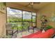 Charming screened lanai features comfortable seating, decor, and serene views of the green backyard at 11819 Sistine Ln, Venice, FL 34293