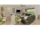 Cozy living room with comfortable seating, a decorative media center, and a view of the backyard at 11819 Sistine Ln, Venice, FL 34293