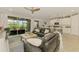 Open-concept living room with comfortable seating, sliding glass doors, and a view into the kitchen at 11819 Sistine Ln, Venice, FL 34293