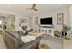 Comfortable living room featuring a ceiling fan, stylish decor, and ample natural light at 11819 Sistine Ln, Venice, FL 34293