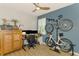 Home office with mounted bicycles, monitors, ceiling fan, and natural light at 11819 Sistine Ln, Venice, FL 34293