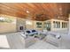 Inviting outdoor lounge area featuring comfortable seating and a stone fireplace at 11819 Sistine Ln, Venice, FL 34293