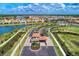 Scenic community entrance showcasing lush landscaping, a lake with fountains, and beautiful homes at 11819 Sistine Ln, Venice, FL 34293