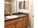 Bathroom vanity with granite counters, light wood cabinets, and double mirrors above at 1271 Jonah Dr, North Port, FL 34289