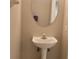 Bathroom features a modern pedestal sink and a mirrored wall cabinet at 1271 Jonah Dr, North Port, FL 34289