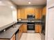 Well-lit kitchen features stainless steel appliances and wood cabinets at 1271 Jonah Dr, North Port, FL 34289