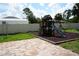 Spacious backyard featuring a playset, patio, and a white privacy fence at 1480 Wise Dr, North Port, FL 34286