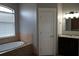 Bathroom featuring a soaking tub with stone accents and a vanity with granite countertops at 1480 Wise Dr, North Port, FL 34286