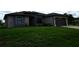 Charming one-story home with lush green lawn, gray stucco exterior, and arched front entry at 1480 Wise Dr, North Port, FL 34286