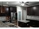 Modern kitchen featuring dark wood cabinets, granite countertops, stainless steel appliances, and a center island at 1480 Wise Dr, North Port, FL 34286