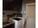 Well-organized laundry room with sink, washer, dryer, and dark wood cabinets at 1480 Wise Dr, North Port, FL 34286