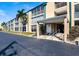 Low-rise building featuring a covered entry and well-maintained landscaping with palm trees at 150 Harborside Ave # 124, Punta Gorda, FL 33950