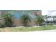 Community mural of a pool, palm trees, and cabanas with a grassy patch and fence in front at 150 Harborside Ave # 124, Punta Gorda, FL 33950