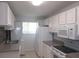 Kitchen featuring white cabinets, appliances, and countertops and a tiled backsplash at 150 Harborside Ave # 124, Punta Gorda, FL 33950