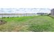 Large, grassy backyard featuring a black metal fence with beautiful lake views and a manicured lawn at 17213 Bullhorn Cir, Punta Gorda, FL 33982