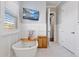 Bright bathroom featuring a soaking tub, tiled floor, paneled wall, and modern fixtures at 17213 Bullhorn Cir, Punta Gorda, FL 33982