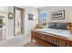 Comfortable bedroom with a wood frame bed, window with blinds, and ensuite bathroom entrance at 17213 Bullhorn Cir, Punta Gorda, FL 33982