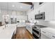 Bright kitchen featuring white cabinetry, stainless steel appliances, an island, and wood flooring at 17213 Bullhorn Cir, Punta Gorda, FL 33982