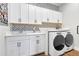 Laundry room with patterned accent wall and front-load washer and dryer at 17213 Bullhorn Cir, Punta Gorda, FL 33982