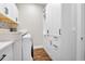 Modern laundry room with front load washer, white cabinets, quartz countertops, and stylish backsplash at 17213 Bullhorn Cir, Punta Gorda, FL 33982