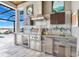 Outdoor kitchen with stainless steel appliances, custom backsplash and tile work at 17213 Bullhorn Cir, Punta Gorda, FL 33982