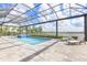 Large screened-in pool with a spa and lounge chairs, offering a serene outdoor space with lake views at 17213 Bullhorn Cir, Punta Gorda, FL 33982