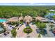 Aerial view of the clubhouse, community pool, circular drive, and lush tropical landscaping at 181 Padova Way # 19, Nokomis, FL 34275