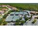Aerial view of the community tennis courts, pool, clubhouse, trees, lake and wooded area at 181 Padova Way # 19, Nokomis, FL 34275