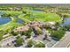 Scenic aerial view of the clubhouse, showcasing the lush golf course, sparkling lakes, and upscale community at 181 Padova Way # 19, Nokomis, FL 34275