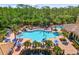 An aerial view showing a large community pool with surrounding lounge chairs and palm trees at 181 Padova Way # 19, Nokomis, FL 34275