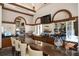 Elegant full bar with dark wood cabinets, a stone countertop, and mirrored shelving displaying a variety of liquors at 181 Padova Way # 19, Nokomis, FL 34275