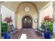 Elegant building entrance with large wooden doors, stone pillars, and decorative planters at 181 Padova Way # 19, Nokomis, FL 34275