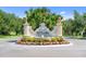 Welcoming entrance to the Venetian Golf & River Club with colorful flowers and sculpted lion statues at 181 Padova Way # 19, Nokomis, FL 34275